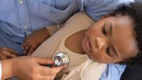 Doctor using a stethoscope to check a baby.